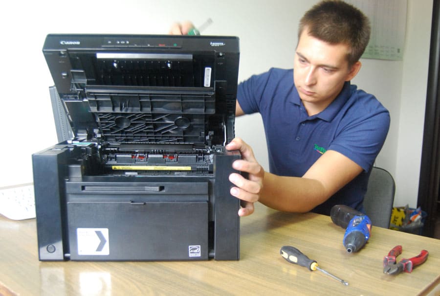 Мастер ремонтирует принтер
